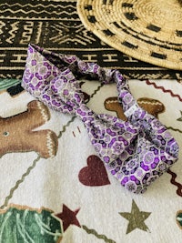 a purple paisley headband on a rug