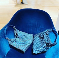 two bags sitting on a blue chair in a store