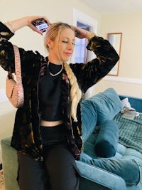 a woman is sitting on a couch holding a purse