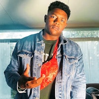 a man wearing a denim jacket and a red fanny pack