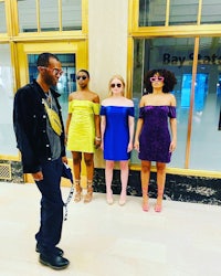a group of women standing in front of a building