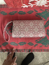 a person holding a bag on a red rug