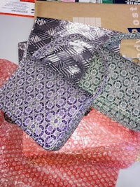 two purses sitting on a table next to each other
