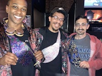 three men posing for a photo in a bar