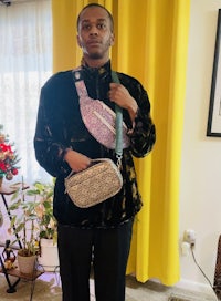 a man in a black jacket holding two purses